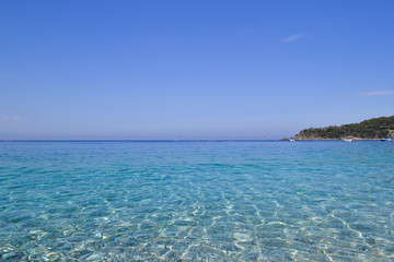 Fototapeta na wymiar Sea view. Transparent water and calm turquoise sea with sun highlights