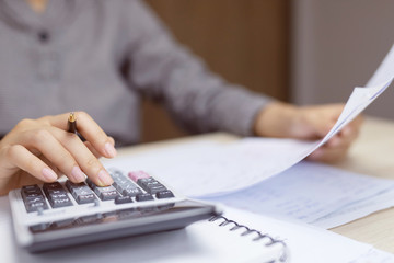 Close up business woman hand using calculator counting making Calculate the cost of checking...