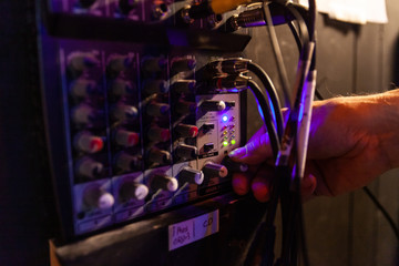 Sound engineer using equipment at work. A close up view on the hand of a music producer using audio...