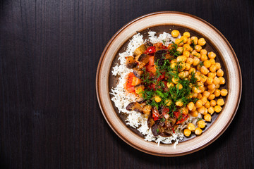 Rice with chickpea and vegetables on wooden table