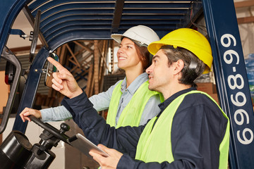 Logistics worker with tablet and forklift