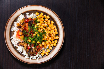 Rice with chickpea and vegetables on wooden table