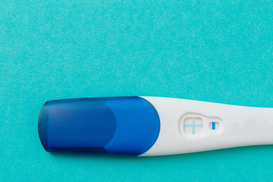 Positive White Plastic Pregnancy Test on blue  Background. - Image
