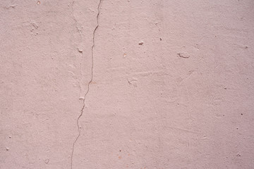 Old pink wall with crack and plaster. textured background