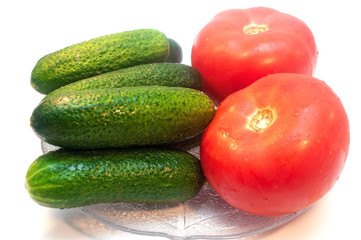 Cucumbers with tomatoes in a plate on a white background