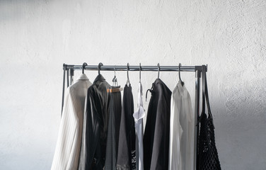stylish clothes hanging on hangers on white background