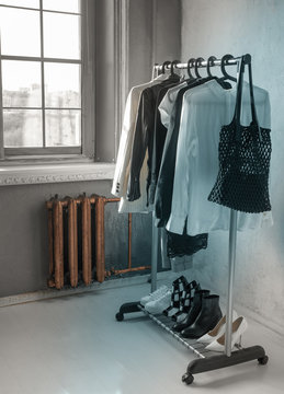 stylish clothes hanging on hangers against the window