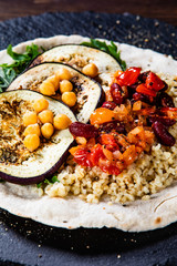 Groats with sauce and vegetables on tortilla
