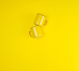 two yellow ceramic cups with a handle