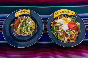 Organic produce sold at farmer's market. A high angled and close up view of two dishes, containing tostadas and chilaquiles, Mexican foods served at a hoot food vendor stall during a local food fair.