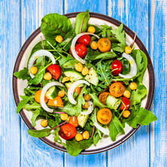 Greek salad with chickpea on wooden background