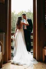Full length portrait of a beautiful bride and groom embracing on the balcony before wedding looking...