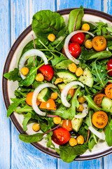 Greek salad with chickpea on wooden background