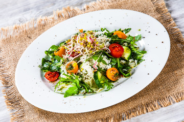 Salad with white rice on wooden background