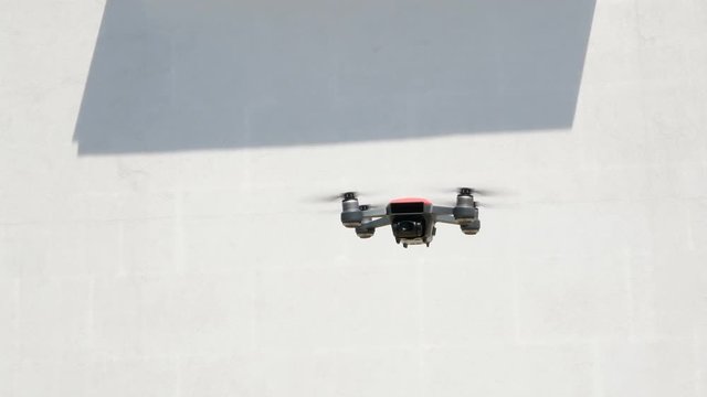Drone in the air. Rotating drone in blue sky