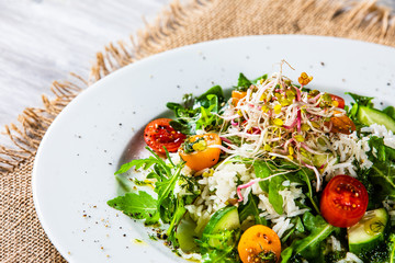 Salad with white rice on wooden background