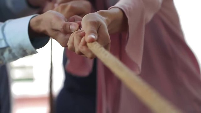 Concept image of business colleagues using rope as element of teamwork