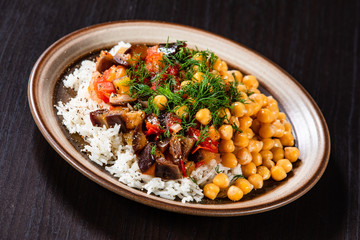 Rice with chickpea and vegetables on wooden table