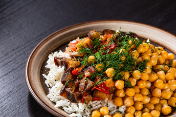 Rice with chickpea and vegetables on wooden table