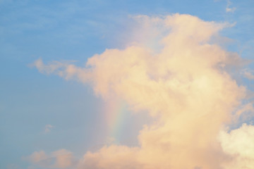 Pink clouds at sunset with a rainbow.
