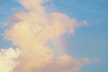 Pink clouds at sunset with a rainbow.