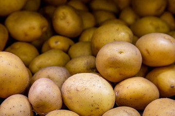 A full frame photograph of potatoes for sale on a market stall