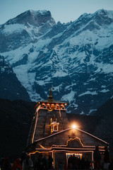 View of the Kedarnath temple lights at night with mountains in the background in Uttarakhand, India