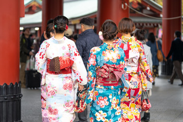 Young girl wearing Japanese kimono standing in front of Sensoji Temple in Tokyo, Japan. Kimono is a...