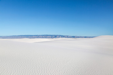 Fototapeta na wymiar A view of the vast sand dunes at White Sands National Monument, with a clear blue sky overhead