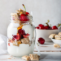 Bitesize shredded wheat with fresh cherry berries in Jar