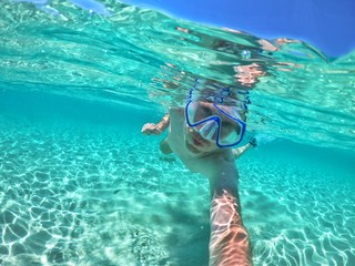 Mann mit Tauchermaske und Schnorchel unterwasser beim Tauchen bzw. Schnorcheln in klarem türkisen...