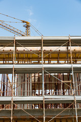 Naklejka premium Scaffolds and cranes in a construction site