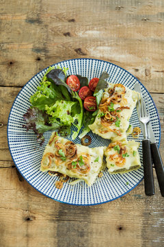 Maultaschen mit ger&ouml;steten Zwiebeln, K&auml;se, Salat und Tomaten, Studio