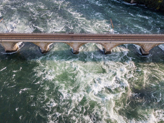 Aerial view of railway bridge with one track across rhine river in Switzerland.