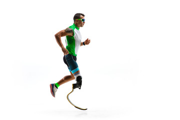 Athlete with disabilities or amputee isolated on white studio background. Professional male runner with leg prosthesis training and practicing in studio. Disabled sport and healthy lifestyle concept.