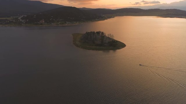 Lake landscape sunrise over water cinematic drone footage - aerial shot of a dam in Bulgaria during sunset