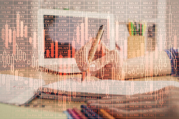 Financial forex charts displayed on woman's hand taking notes background. Concept of research....