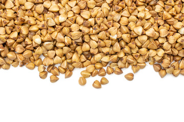 Lot of whole raw brown buckwheat grain with copyspace below flatlay isolated on white background