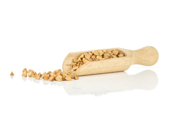 Lot of whole hulled raw brown buckwheat grain with wooden scoop isolated on white background