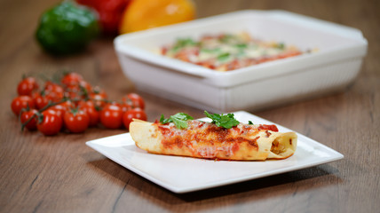 Traditional mexican enchiladas with chicken meat, spicy tomato sauce and cheese on a plate. Mexican cuisine.