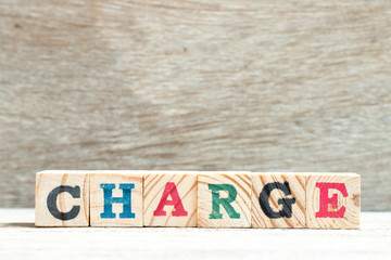 Alphabet letter block in word charge on wood background