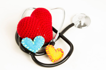 Heart health and prevention concept. Stethoscope and red heart of crochet on white isolated...