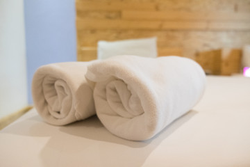 Fototapeta na wymiar Roll of white towel on bed