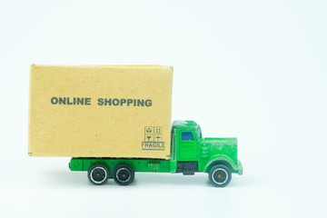 Miniature cardboard boxes on green toy truck carries