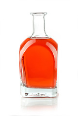 glass bottle with a red liquid on white background