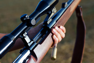 Woman hunter loading bullet to carbine 