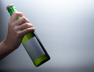 Butylka iz zelenogo stekla kotoruyu derzhit zhenskaya ruka.54/5000.A bottle of green glass that...