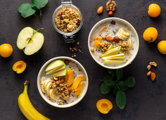 Granola bowl with fruits, nuts, milk and peanut butter in bowl on a white background. Healthy breakfast cereal top view
