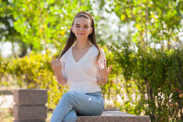 Young beautiful woman sitting on bench in park.