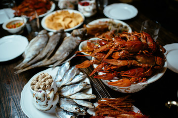 boiled crayfish, salted fish, snacks on a wooden table